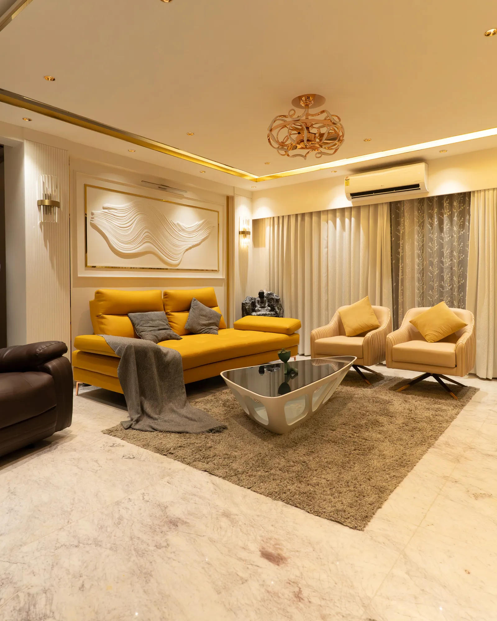 Living room with mustard sofa, gold-trimmed ceiling and sculpted wall panel — Divyarjuna